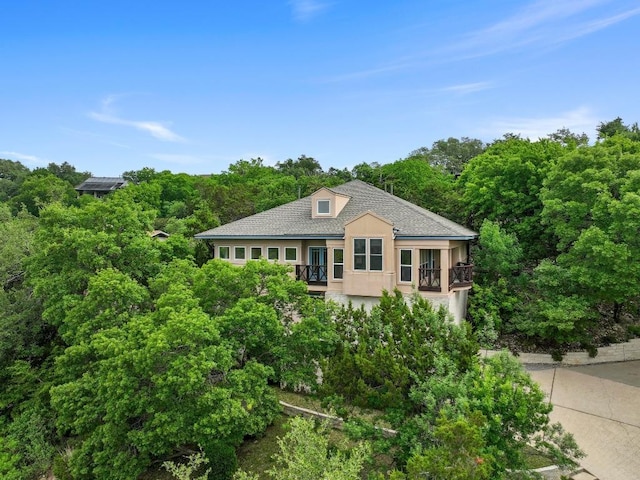 3800 Laurel Ledge Ln, Austin, TX 78731 - view of front of home featuring stucco siding, a balcony, and a view of trees