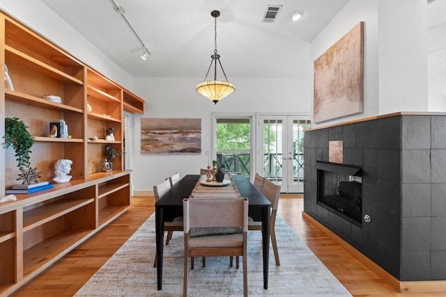 3800 Laurel Ledge Ln, Austin, TX 78731 - dining space featuring french doors, light wood-style floors, track lighting, and a fireplace