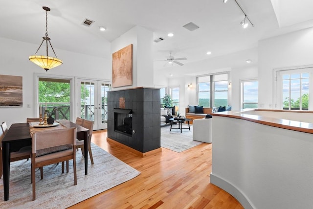 3800 Laurel Ledge Ln, Austin, TX 78731 - dining room with light wood finished floors, a tiled fireplace, rail lighting, and a ceiling fan
