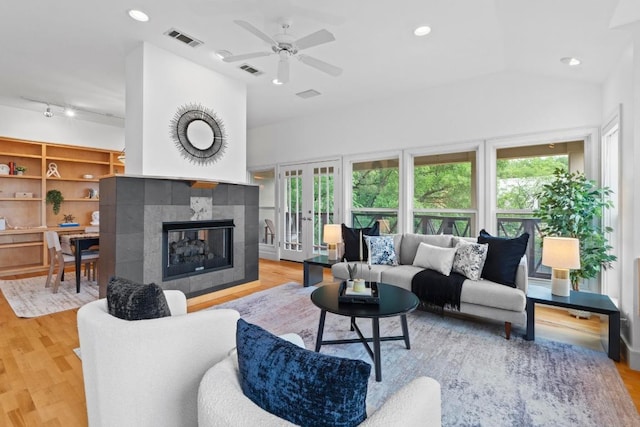3800 Laurel Ledge Ln, Austin, TX 78731 - living room with healthy amount of natural light, light wood-type flooring, ceiling fan, a tile fireplace, and lofted ceiling