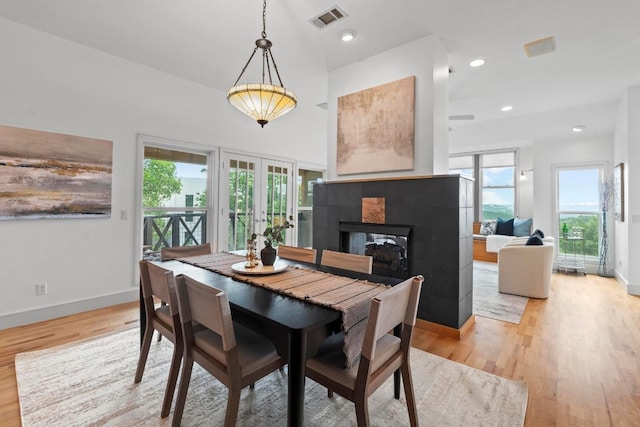 3800 Laurel Ledge Ln, Austin, TX 78731 - dining space featuring french doors, light wood-style flooring, a fireplace, and baseboards