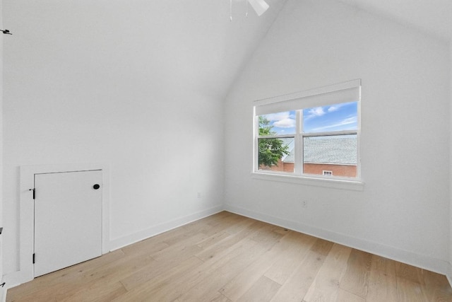 additional living space featuring light wood-type flooring, baseboards, ceiling fan, and vaulted ceiling