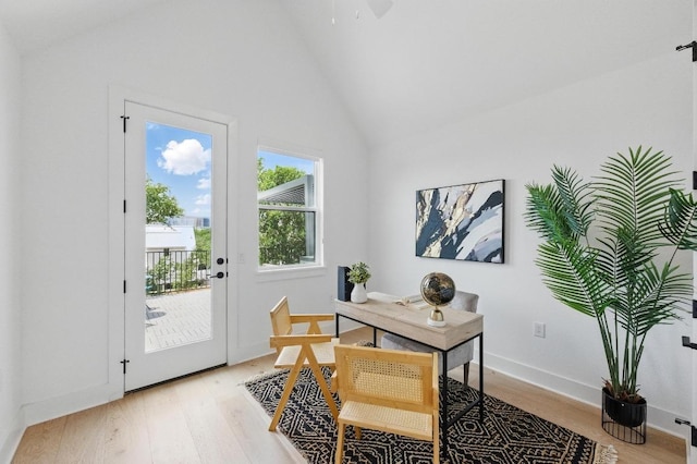 home office with high vaulted ceiling, ceiling fan, baseboards, and light wood-style flooring