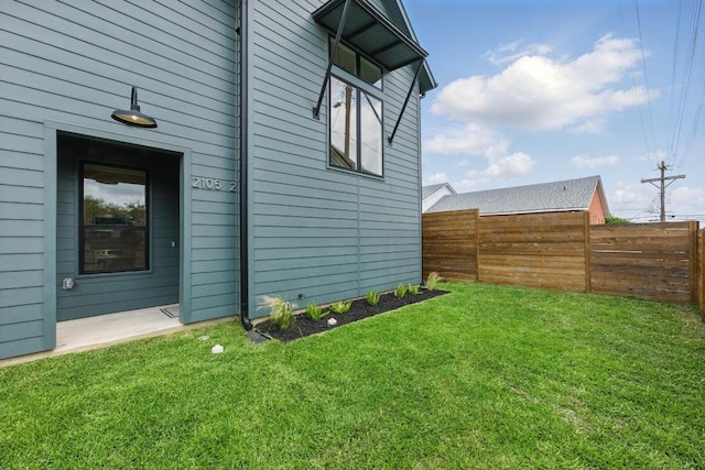 exterior space featuring fence and a lawn