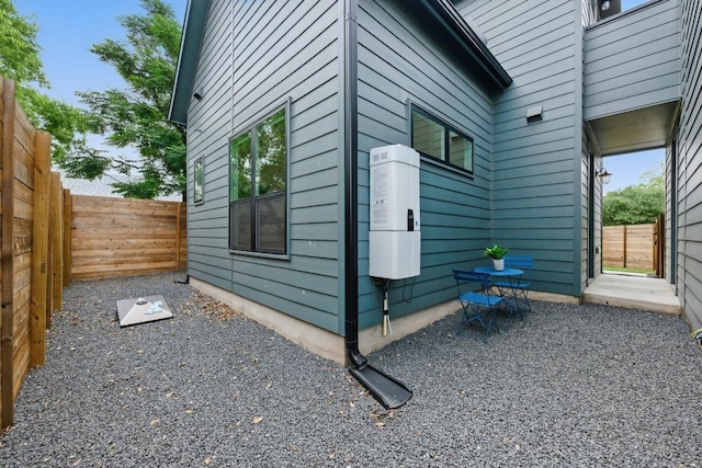 view of side of home with a fenced backyard and a patio area