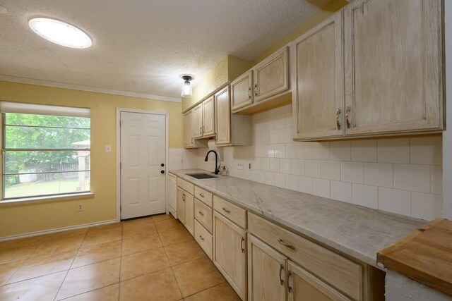 7103 Howerington Cir, Austin, TX 78724 - kitchen featuring a sink, a textured ceiling, backsplash, light brown cabinets, and light tile patterned flooring