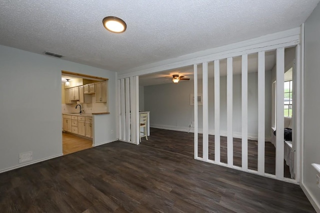 7103 Howerington Cir, Austin, TX 78724 - unfurnished living room with wood finished floors, a sink, a textured ceiling, a ceiling fan, and baseboards