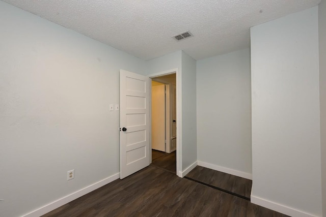 7103 Howerington Cir, Austin, TX 78724 - unfurnished room featuring dark wood-type flooring, baseboards, and a textured ceiling