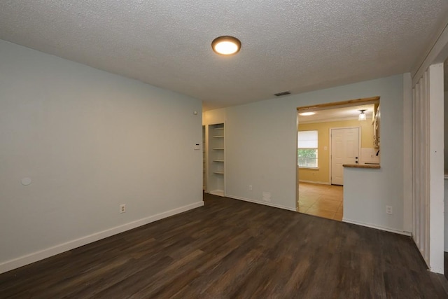 7103 Howerington Cir, Austin, TX 78724 - empty room with wood finished floors, a textured ceiling, and baseboards