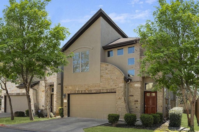 view of front facade with fence, stone siding, a garage, stucco siding, and concrete driveway