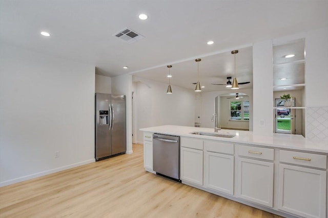 kitchen featuring appliances with stainless steel finishes, a sink, a ceiling fan, light wood-type flooring, and visible vents
