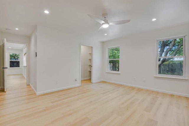 empty room featuring recessed lighting, a wealth of natural light, and light wood finished floors