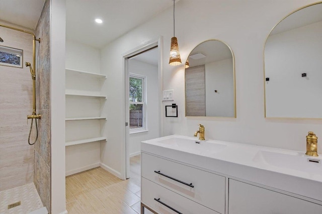 full bath with double vanity, tiled shower, a sink, and recessed lighting