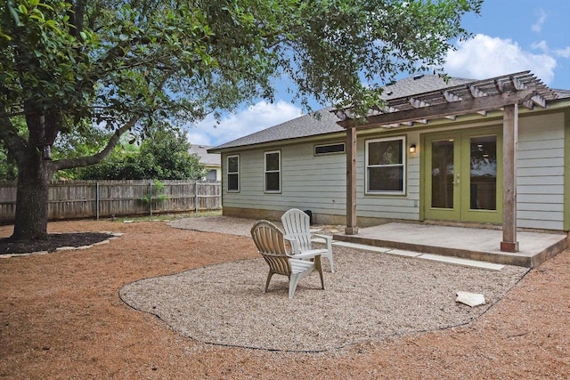 back of property featuring a patio, a fenced backyard, roof with shingles, and french doors
