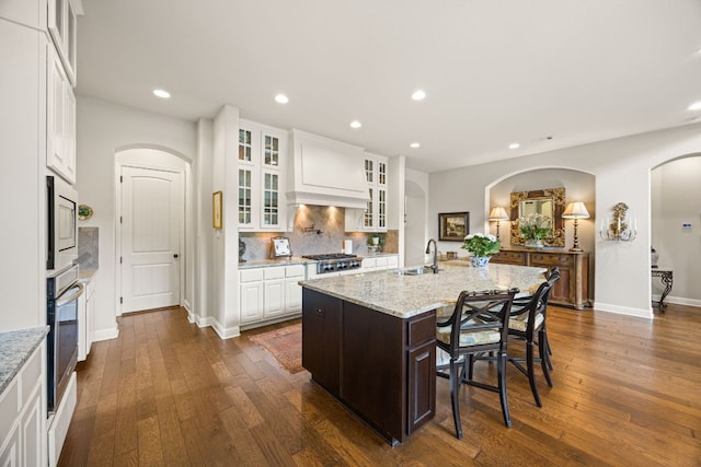 103 Maddy Way, Austin, TX 78738 - kitchen with arched walkways, stainless steel appliances, recessed lighting, and dark wood-type flooring