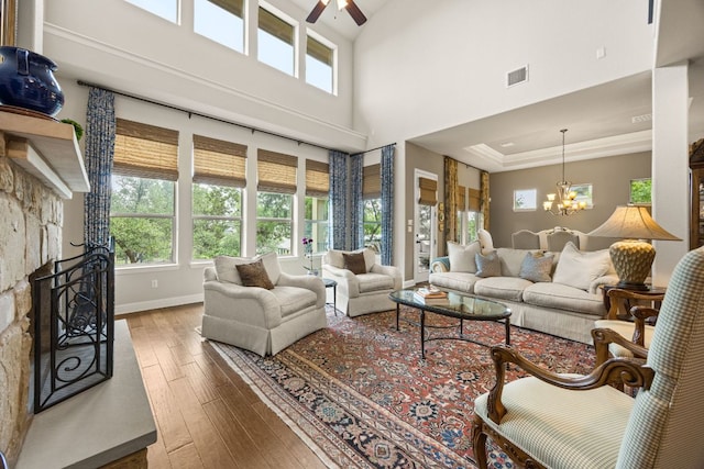 103 Maddy Way, Austin, TX 78738 - living area with hardwood / wood-style flooring, ceiling fan, a chandelier, a high ceiling, and a raised ceiling