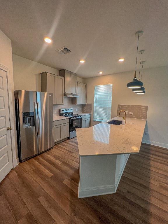 kitchen with appliances with stainless steel finishes, a sink, gray cabinets, visible vents, and dark wood-style floors