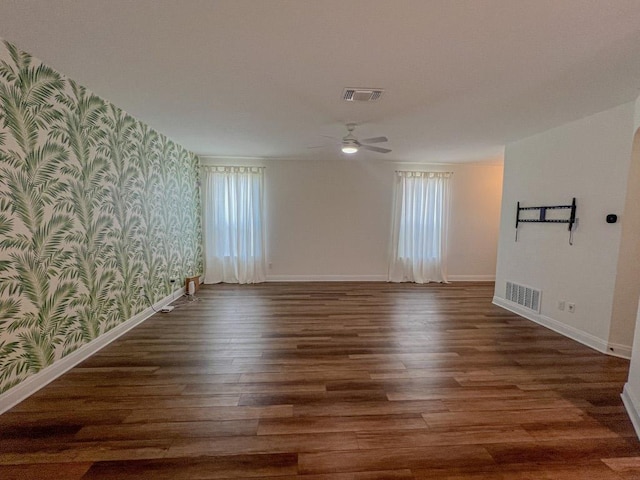 empty room featuring baseboards, plenty of natural light, wallpapered walls, and visible vents