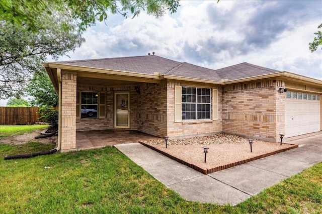 view of front facade with fence, an attached garage, a front lawn, and brick siding