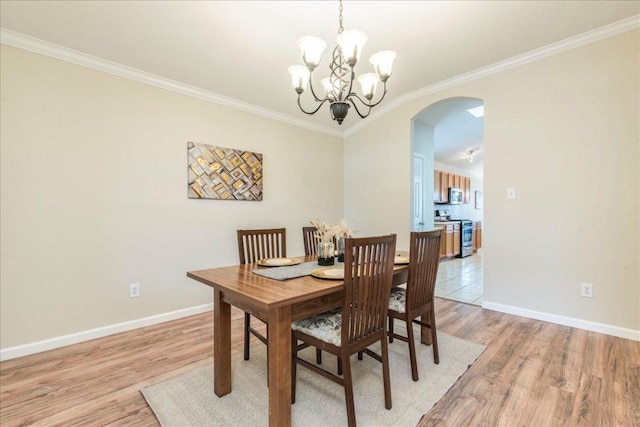 118 San Gabriel Dr, Kyle, TX 78640 - dining space with a notable chandelier, baseboards, ornamental molding, arched walkways, and light wood-style floors