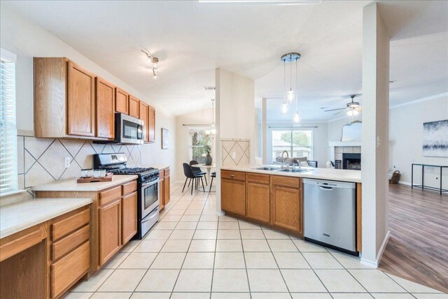 118 San Gabriel Dr, Kyle, TX 78640 - kitchen featuring appliances with stainless steel finishes, a ceiling fan, a sink, tasteful backsplash, and light countertops