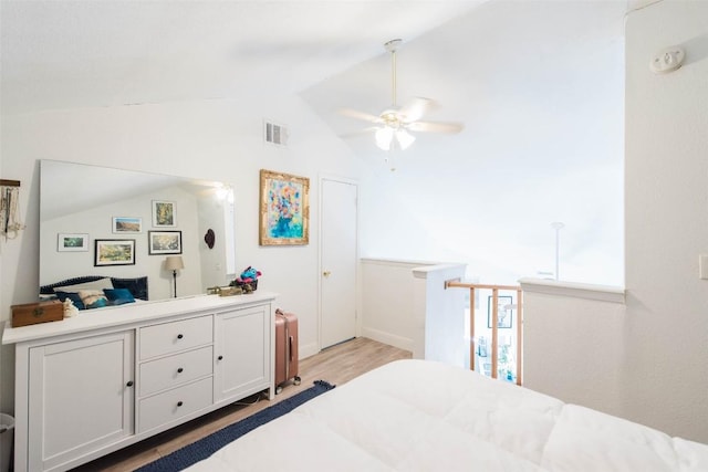 bedroom with visible vents, wood finished floors, and lofted ceiling