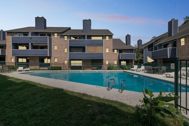 pool with a yard, fence, and a patio area