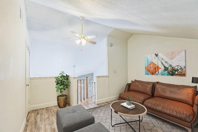 2500 Burleson Rd Unit 321, Austin, TX 78741 - living area featuring ceiling fan, a textured ceiling, baseboards, wood finished floors, and lofted ceiling