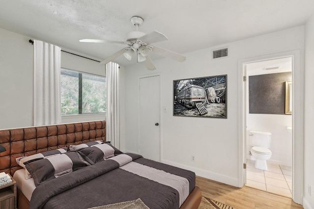 2500 Burleson Rd Unit 321, Austin, TX 78741 - bedroom with a ceiling fan, visible vents, light wood-type flooring, baseboards, and ensuite bathroom