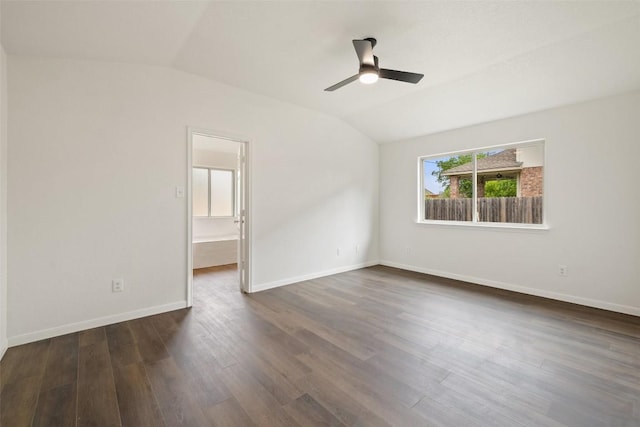 spare room featuring baseboards, ceiling fan, dark wood-style flooring, and lofted ceiling