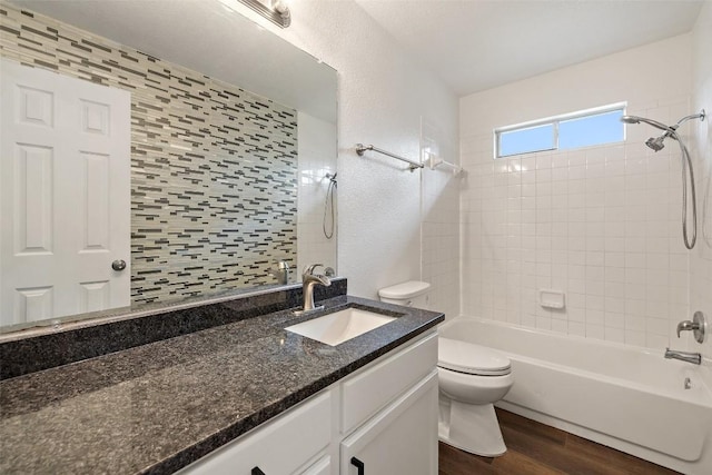bathroom with toilet, bathing tub / shower combination, wood finished floors, and vanity