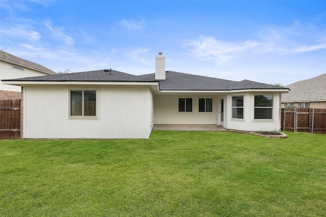 rear view of house featuring a lawn, a chimney, a fenced backyard, and a patio area