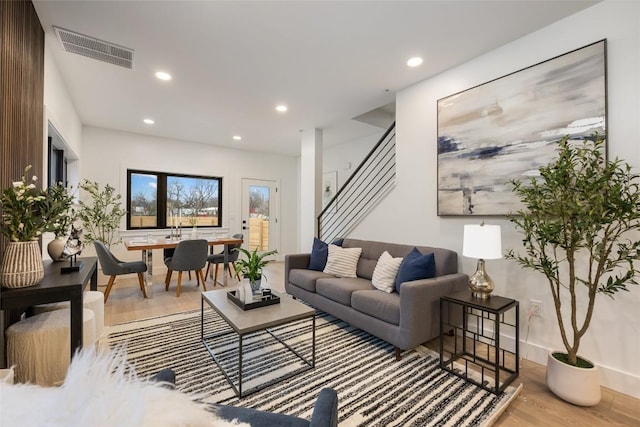 living area featuring visible vents, recessed lighting, stairs, and wood finished floors
