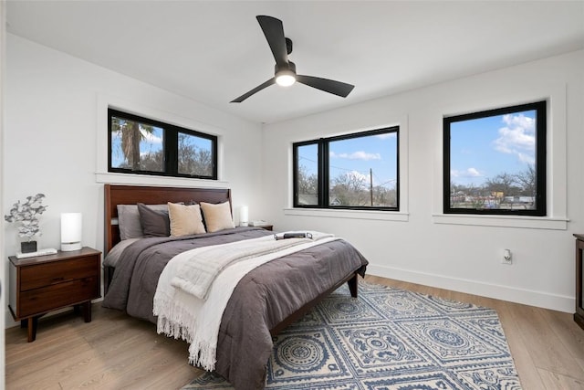 bedroom featuring baseboards, ceiling fan, and light wood-type flooring