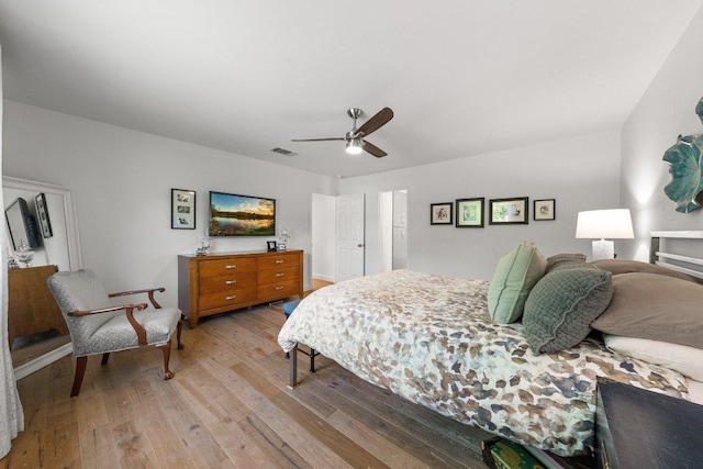 bedroom with a ceiling fan, wood finished floors, and visible vents