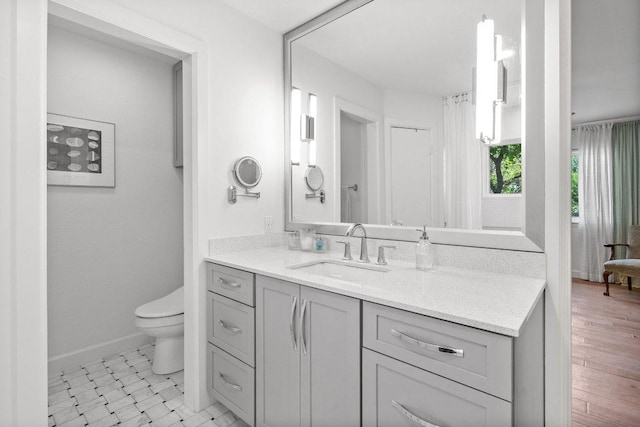 full bath featuring toilet, baseboards, and vanity