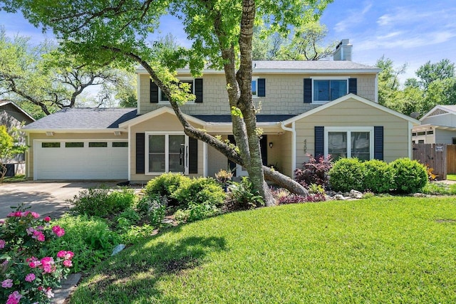 traditional home with fence, a garage, a front yard, a chimney, and driveway