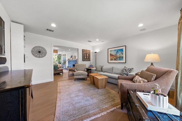 living room featuring recessed lighting, baseboards, visible vents, and wood finished floors