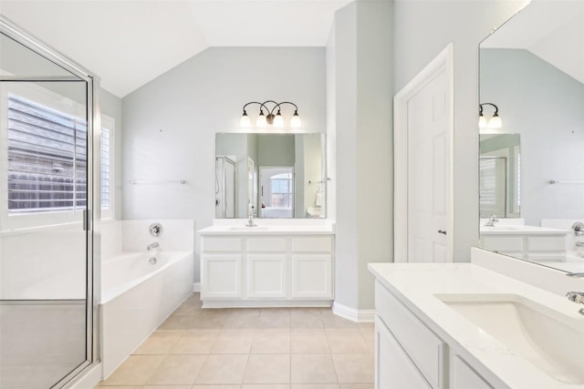 full bathroom with tile patterned floors, a sink, lofted ceiling, and a garden tub
