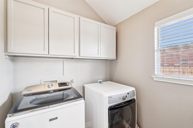 laundry area featuring a healthy amount of sunlight, cabinet space, and washer and dryer
