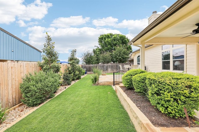 view of yard featuring a fenced backyard and a ceiling fan