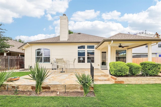 rear view of property featuring a lawn, fence, ceiling fan, and a patio area