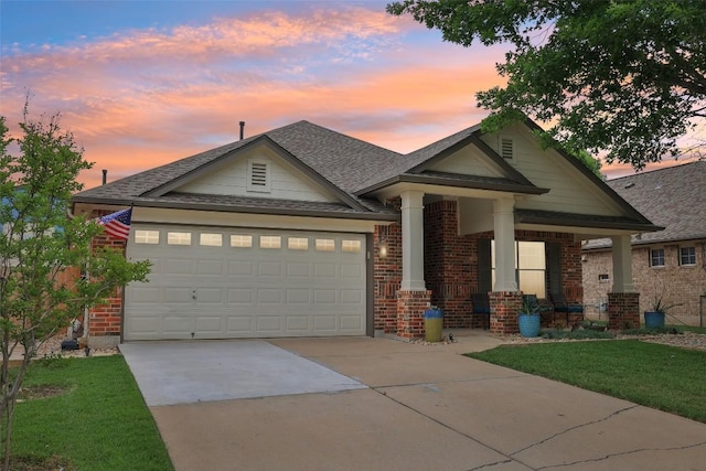 craftsman inspired home with brick siding, a lawn, driveway, and covered porch
