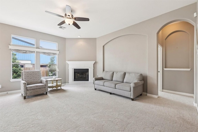 living room with carpet flooring, arched walkways, ceiling fan, and baseboards