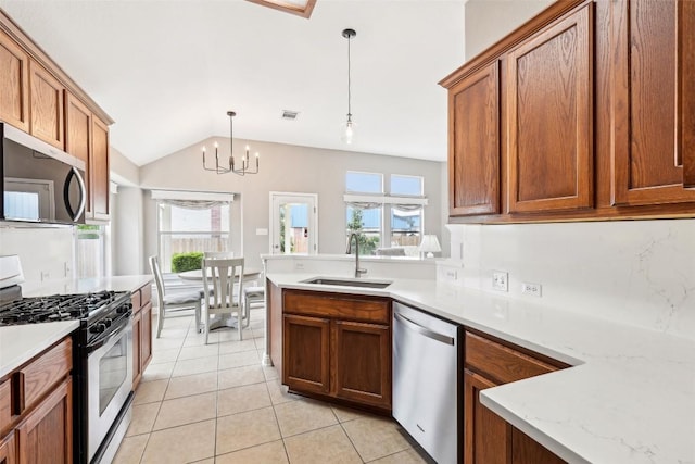 kitchen with brown cabinetry, a sink, light tile patterned floors, vaulted ceiling, and stainless steel appliances