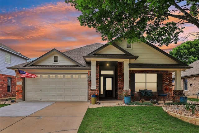 view of front of home with a garage, a front yard, roof with shingles, brick siding, and concrete driveway