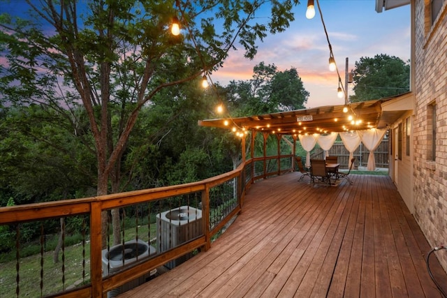 deck at dusk featuring outdoor dining area
