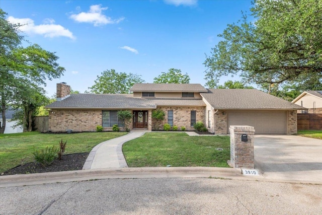 traditional-style home with a chimney, a front yard, brick siding, concrete driveway, and an attached garage