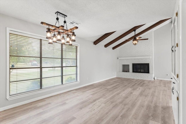 unfurnished living room featuring lofted ceiling with beams, a textured ceiling, ceiling fan with notable chandelier, wood finished floors, and visible vents