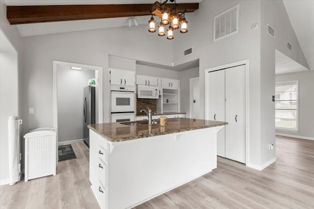 kitchen featuring a sink, white appliances, and visible vents